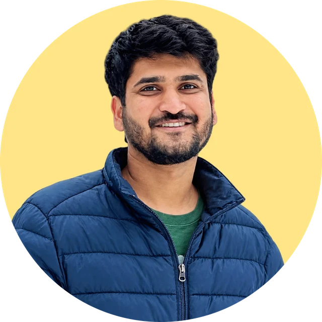 Abhi smiling, in a navy puffer jacket
